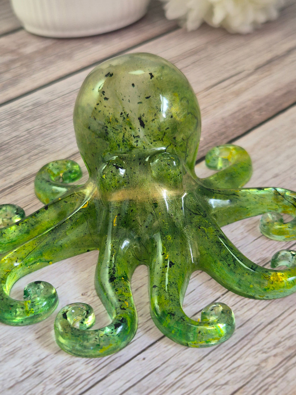 Handmade Green resin octopus ornament on a wooden surface
