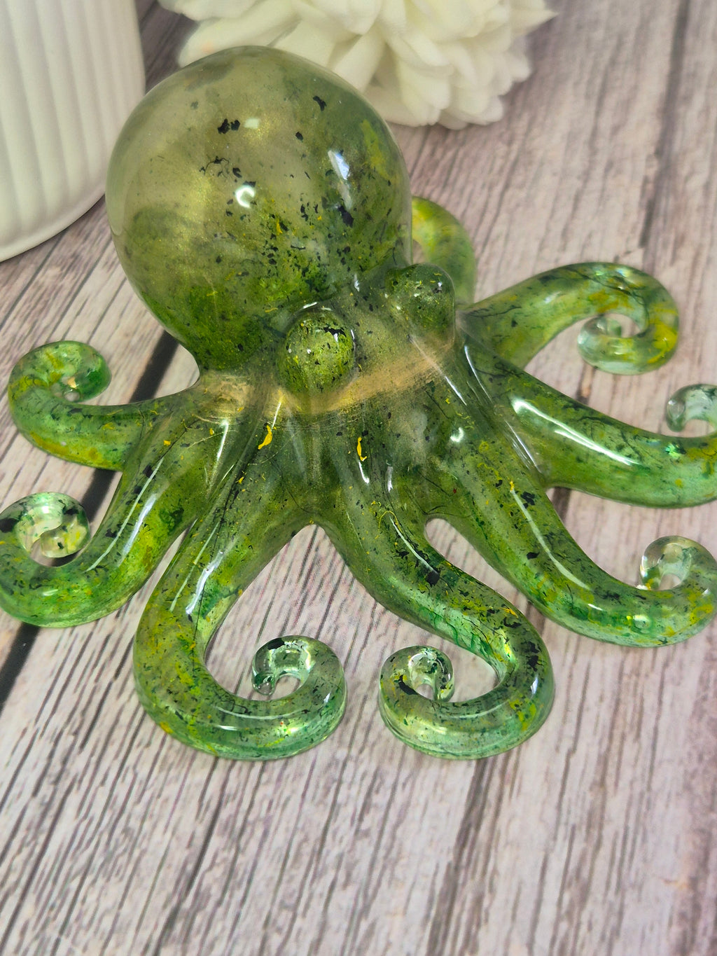 Green handmade resin octopus ornament on a wooden surface