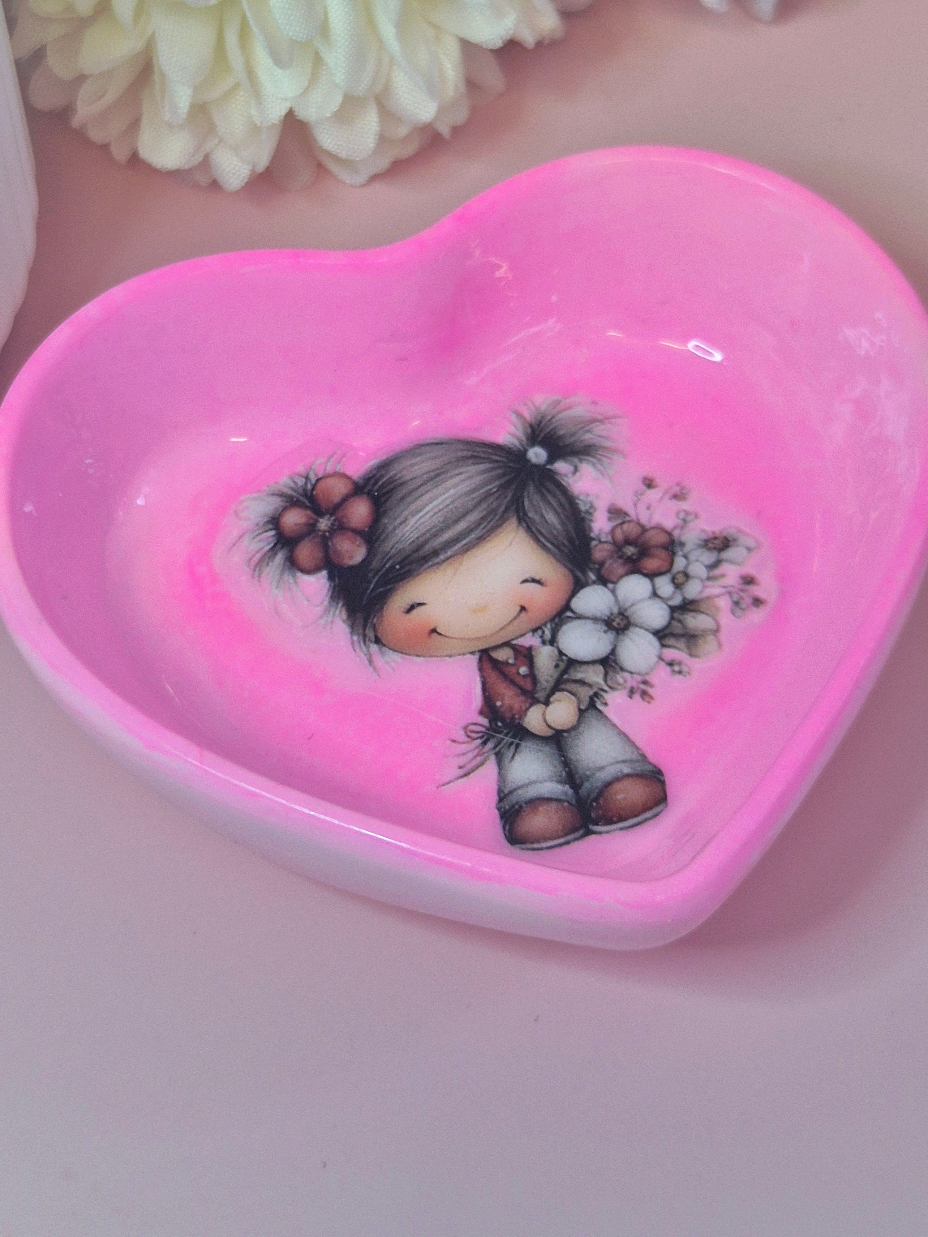 Heart-shaped pink tri ket dish with a girl holding flowers design on a light pink background