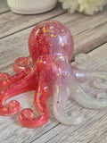 Handmade resin Pink and white octopus ornament on a wooden surface