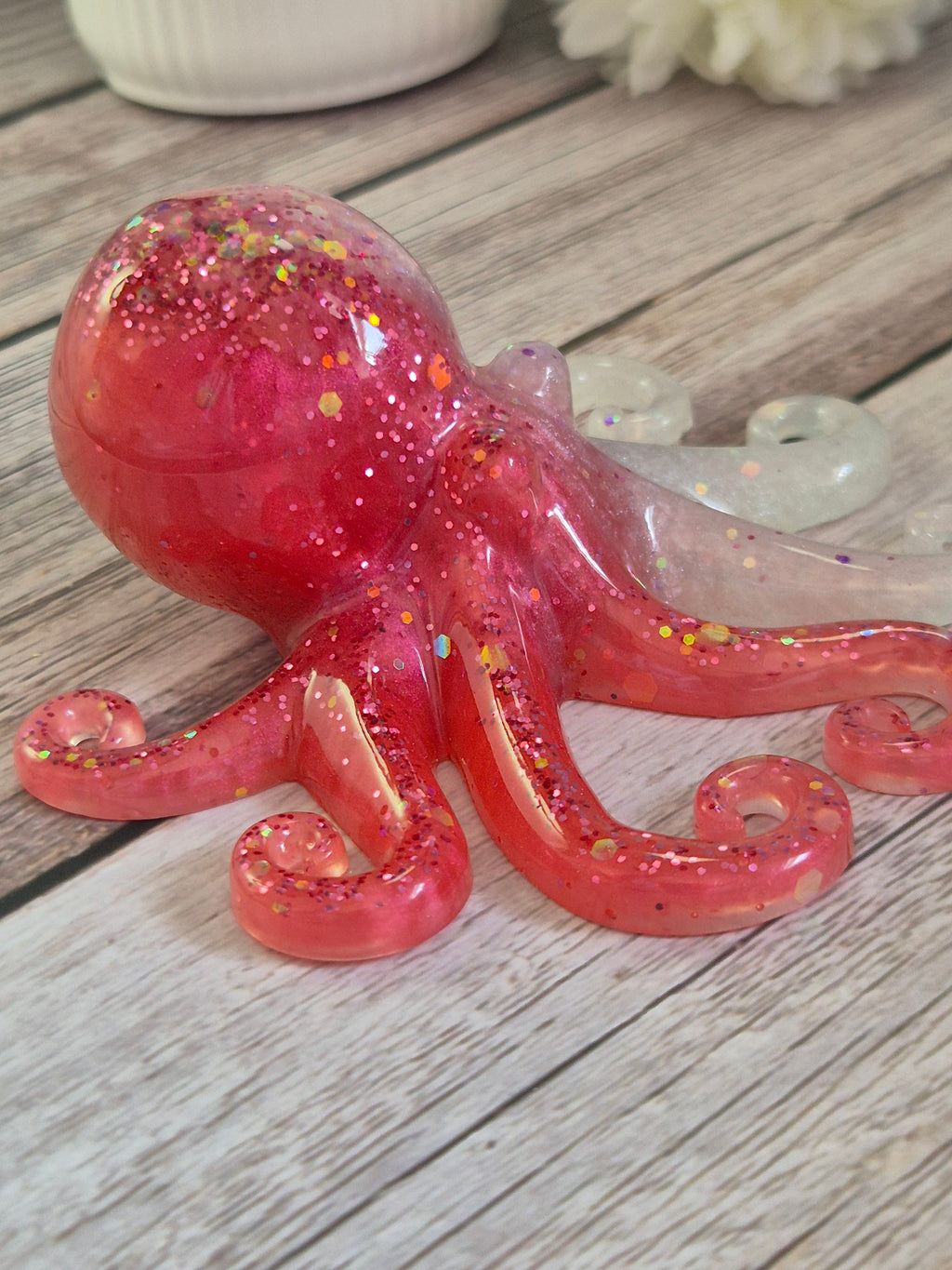 Pink white resin glittery octopus ornament on a wooden surface handmade