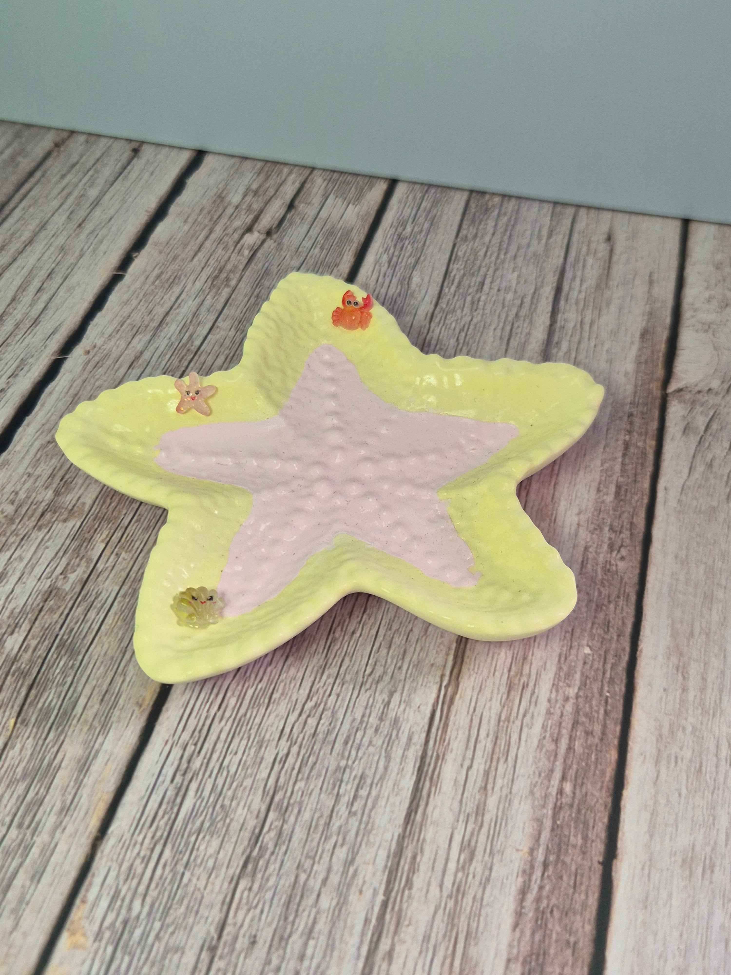 Star-shaped resincrete trinket dish on a textured surface on a wooden surface