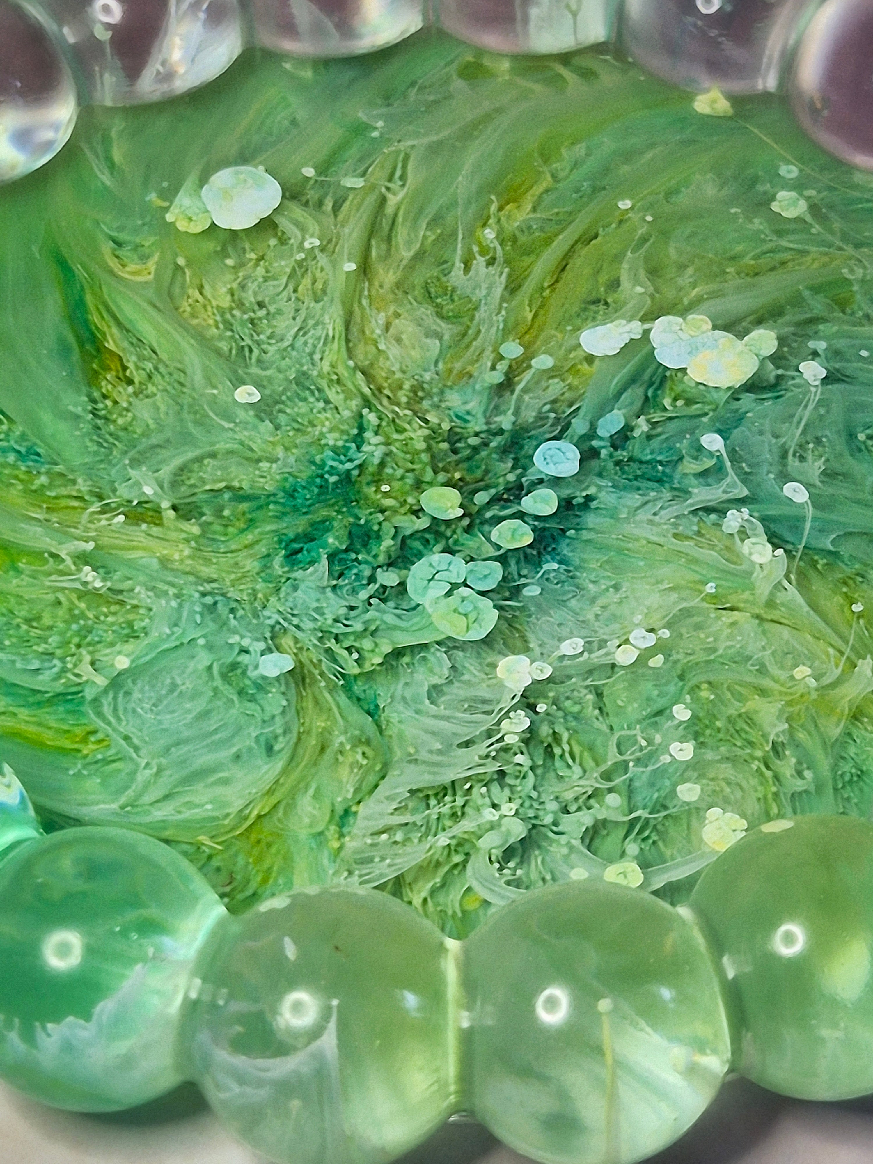 Close up green resin trinket tray with flowing ink patterns throughout 